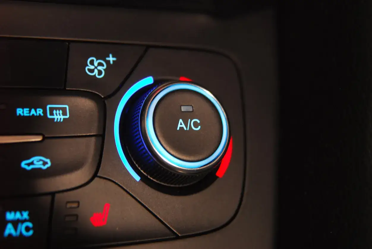 Bouton A/C allumé, avec indicateurs de température et de ventilation. Faut-il laisser la climatisation voiture en permanence ?
