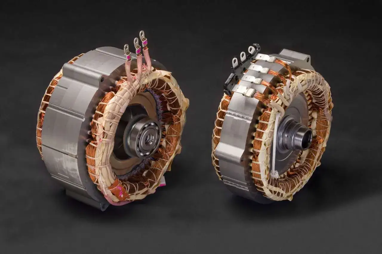 Deux moteurs électriques de voiture hybride non rechargeable, montrant leurs bobinages en cuivre et leurs roulements.
