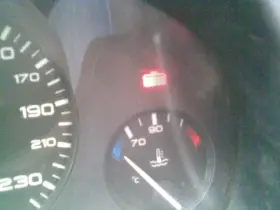 Tableau de bord d'une Peugeot 406 : voyant liquide de refroidissement allumé, aiguille de température à 70°C.