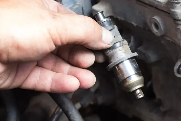 Main tenue un injecteur de carburant, possiblement en raison d'un problème d'injecteur.